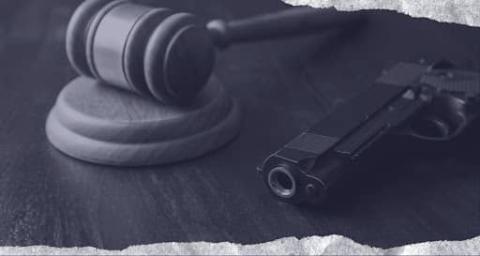 A gavel beside a pistol